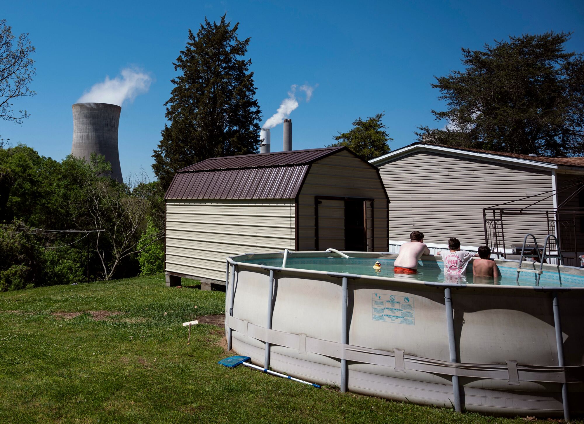 Kids take a break in a swimming pool in the shadow of the James H. Miller, Jr., coal-fired power plant in Adamsville, Alabama.